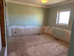 Unfurnished room featuring visible vents, ceiling fan, and crown molding