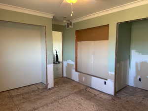 Unfurnished bedroom with visible vents, crown molding, and a ceiling fan