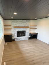 Unfurnished living room with visible vents, baseboards, a stone fireplace, recessed lighting, and light wood-type flooring
