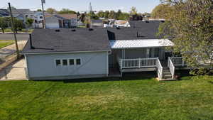 Back of property with roof with shingles, a yard, a residential view, and a deck