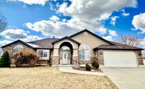 View of front of house featuring concrete driveway, roof with shingles, stucco siding, a garage, and stone siding