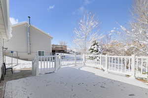 Snowy yard featuring a deck and fence private yard