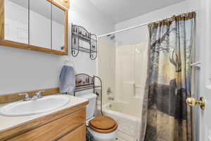 Full bath featuring shower / bath combo with shower curtain, toilet, and vanity