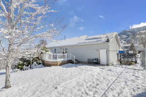 Snow covered property featuring a deck and fence
