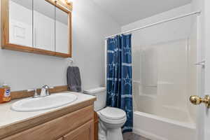 Full bath with toilet, vanity, and shower / bath combo