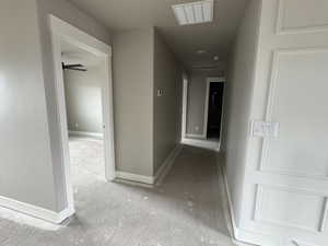 Corridor with baseboards and visible vents