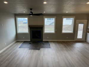 Unfurnished living room with ceiling fan, baseboards, wood finished floors, and recessed lighting