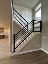 Stairway with recessed lighting, baseboards, and wood finished floors