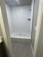 Bathroom featuring tile patterned floors, vanity, shower / bathtub combination, and baseboards