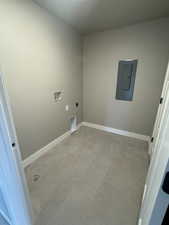 Laundry room with baseboards, electric panel, laundry area, hookup for a washing machine, and hookup for an electric dryer