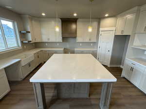 Kitchen with recessed lighting, a center island, dark wood-type flooring, and open shelves