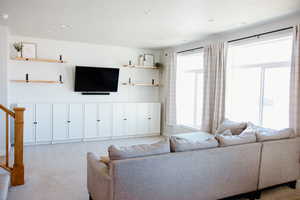 Living room featuring recessed lighting, carpet, built-in cabinetry and shelving.