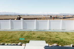 View of yard with fence and a mountain view.