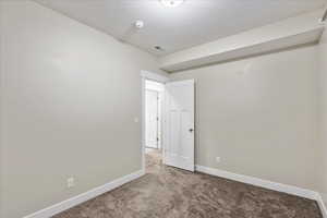 Empty room with visible vents, baseboards, carpet, and a textured ceiling