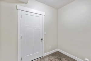 Carpeted spare room featuring baseboards