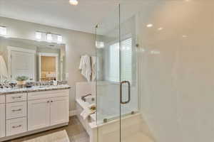 Full bathroom featuring a garden tub, ensuite bathroom, a shower stall, tile patterned flooring, and vanity