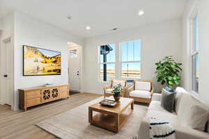 Living room featuring visible vents, recessed lighting, light wood-type flooring, and baseboards