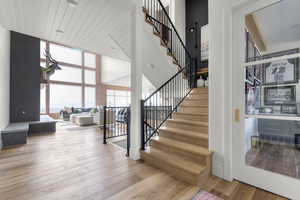 Stairs featuring floor to ceiling windows, a high ceiling, and wood finished floors