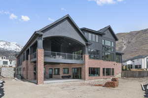Back of house with a mountain view, a patio, brick siding, and central AC unit