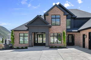View of front of home featuring brick siding, roof with shingles, and a mountain view