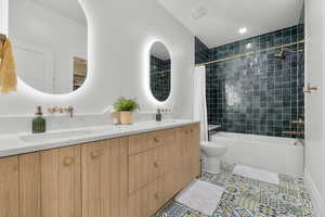 Full bath featuring tile patterned floors, toilet, a sink, shower / bath combination with curtain, and double vanity