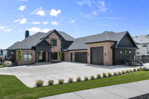 View of front of house featuring brick siding, concrete driveway, roof with shingles, a chimney, and a garage