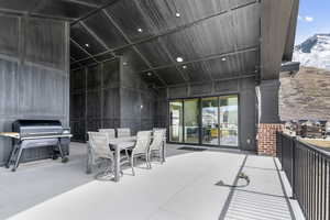 View of patio with area for grilling, a mountain view, and outdoor dining area