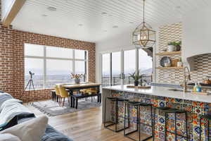 Kitchen featuring wooden ceiling, a wealth of natural light, wood finished floors, and brick wall