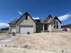 Craftsman-style house with stone siding and a garage