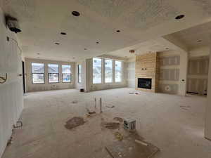Unfurnished living room with a stone fireplace