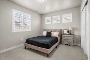 Bedroom with visible vents, baseboards, and carpet floors