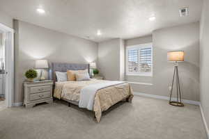 Bedroom featuring visible vents, light colored carpet, and baseboards