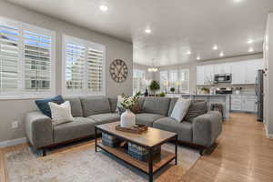 Living area with recessed lighting, a notable chandelier, light wood-style flooring, and a textured ceiling