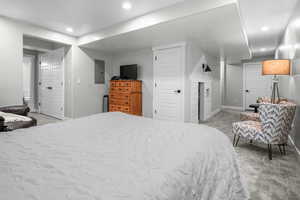 Bedroom featuring electric panel, recessed lighting, baseboards, and light carpet