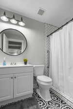 Full bath with visible vents, a shower with curtain, toilet, tile patterned flooring, and vanity