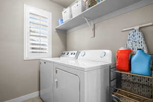 Washroom with tile patterned floors, baseboards, laundry area, and washer and clothes dryer