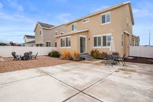 Back of house featuring stucco siding, a patio, a fire pit, and a fenced backyard