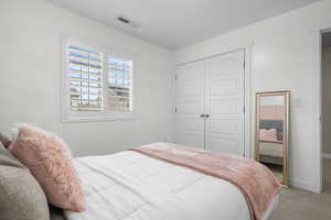 Bedroom featuring a closet, visible vents, baseboards, and carpet