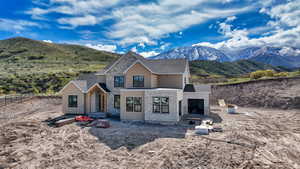 View of front of property with fence, a mountain view, a shingled roof, and stone siding