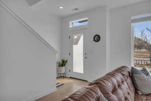 Foyer entrance featuring plenty of natural light, baseboards, visible vents, and light wood-type flooring