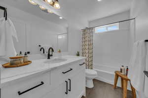 Bathroom with visible vents, toilet, shower / bath combo, tile patterned floors, and vanity