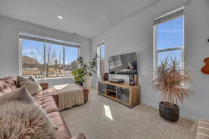 Carpeted living room with visible vents, recessed lighting, and baseboards