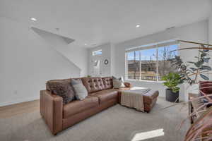 Living area featuring visible vents, recessed lighting, light wood-style floors, and baseboards