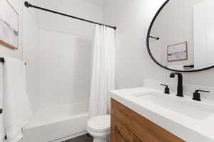 Bathroom with shower / tub combo, toilet, vanity, and tile patterned flooring