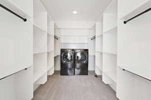 Interior space with light carpet, independent washer and dryer, and laundry area