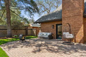 View of patio with an outdoor fire pit and fence