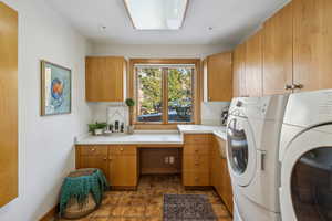 Laundry area featuring washing machine and clothes dryer and cabinet space
