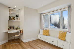 Sitting room featuring recessed lighting, built in study area, light wood-type flooring, and baseboards