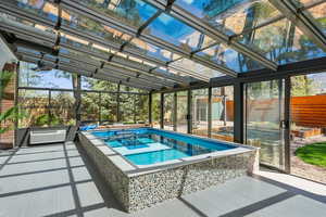 Pool featuring a lanai, a wall unit AC, a patio area, and fence