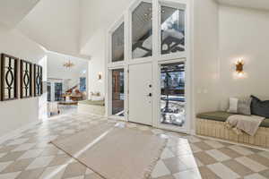 Entryway with baseboards and a towering ceiling